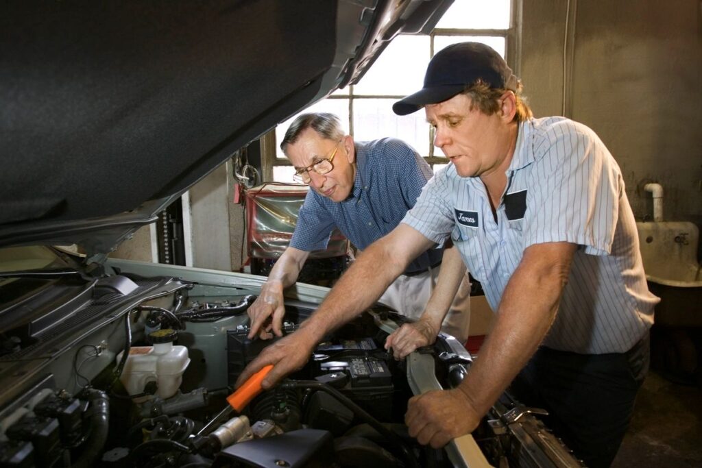 Auto mechanic explaining repair issue to vehicle owner