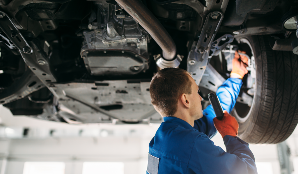 mechanic-with-lamp-checks-car-brake-hoses