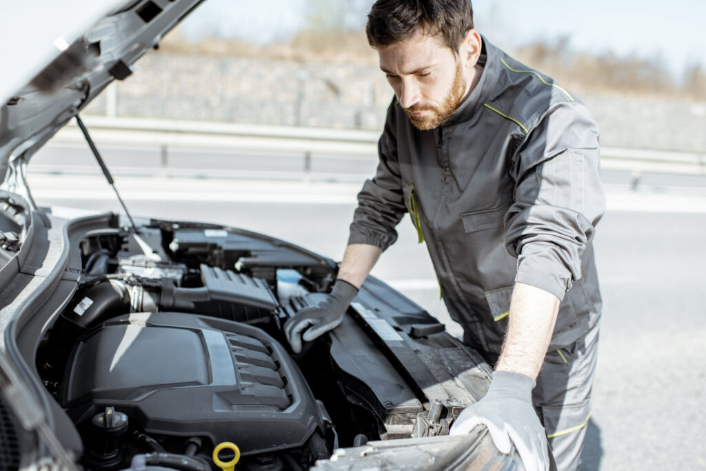 Auto_mechanic_repairing_car_outdoors