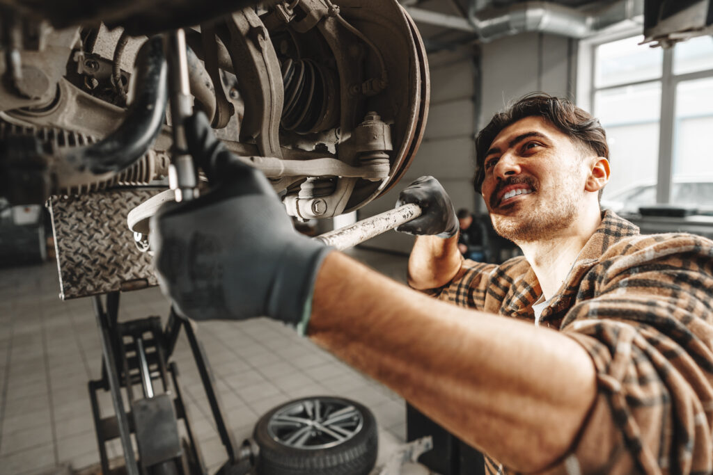 Auto_mechanic_repairs_running_gear_of_a_car